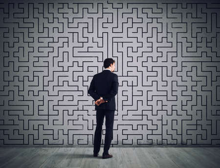 Businessman draws the solution of a labyrinth. Concept of problem solvingの写真素材