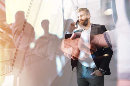Handshaking business person in office. concept of teamwork and partnership. double exposureの写真素材