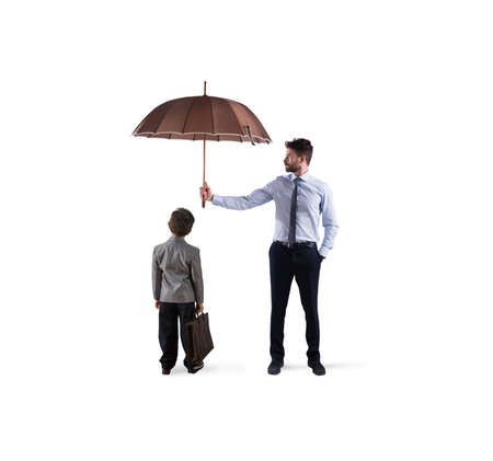 Businessman with umbrella that protect a child. Concept of young economy and startup protectionの写真素材