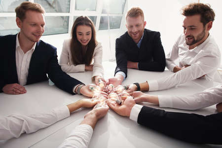 Teamwork and brainstorming concept with businessmen that share an idea with a lamp. Concept of startupの写真素材