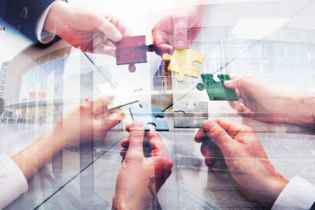 Teamwork of partners. Concept of integration and startup with puzzle pieces. double exposureの写真素材