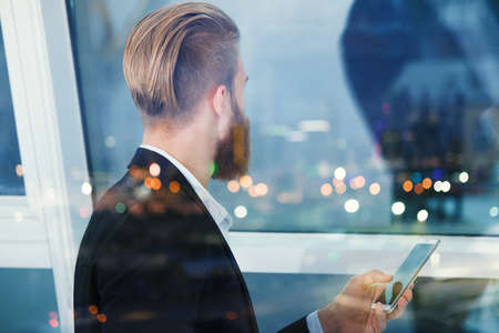 Businessman looks far for the future into the night. Concept of innovation and startupの写真素材
