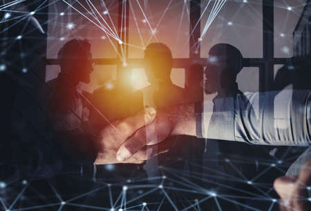 Handshaking business person in office with network effect. concept of teamwork and partnership. double exposureの写真素材