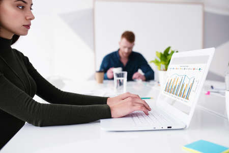 Girl works on a laptop with company statistics. Concept of internet sharing and interconnection