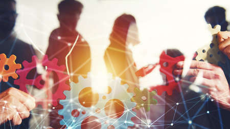 Business team connect pieces of gears. Teamwork, partnership and integration concept with network...
