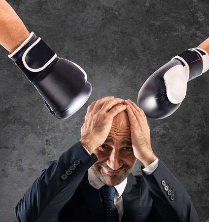 Businessman receives fists from competitors. concept of difficult careerの写真素材