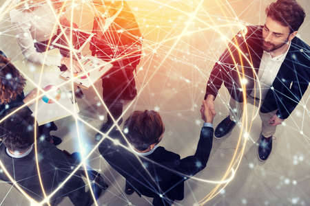 Handshaking business person in office. concept of teamwork and partnership. double exposure with network effectsの写真素材