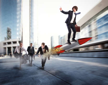 Push to reach the goals before the others. Businessman wins a challenge riding a rocketの写真素材