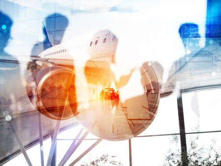 Take off of a modern aircraft and double exposure with silhouettes of passengers in the airportの写真素材