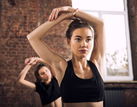 Friend girl do stretching at the gym