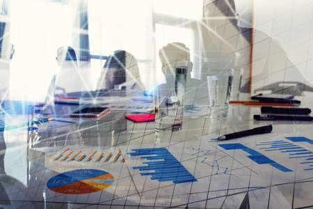 Silhouette of young workers in the office with statistic worksheets. concept of teamwork and...