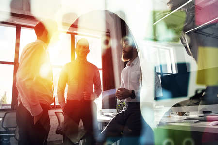 Business people work together in office. Concept of teamwork and partnership. double exposure with light effectsの写真素材