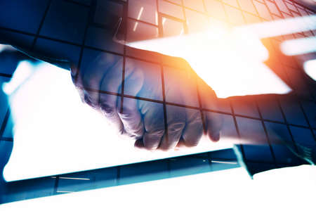 Handshaking business person in office. concept of teamwork and partnership. double exposureの写真素材