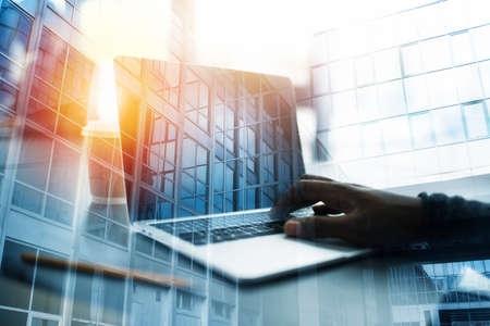 Businessman works in office with a laptop. Concept of internet sharing. double exposure