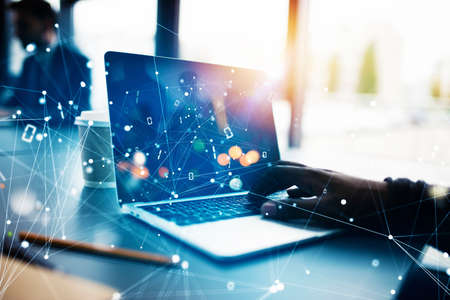 Businessman works in office with a laptop with internet effects. Concept of internet sharing and company startupの写真素材