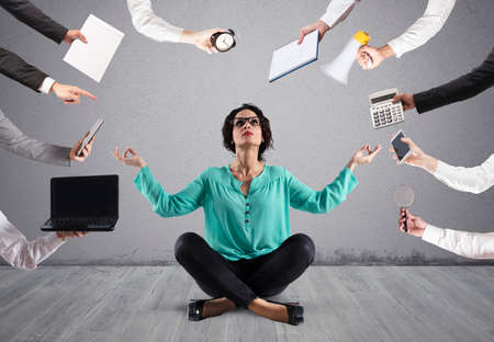 Businesswoman tries to keep calm with yoga due to stress and overwork at wokの写真素材