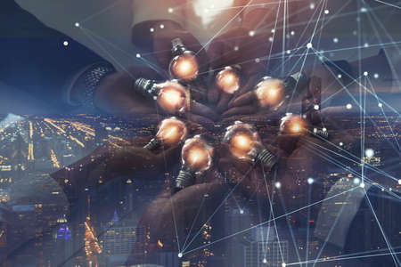 Teamwork and brainstorming concept with businessmen that share an idea with a lamp with network...