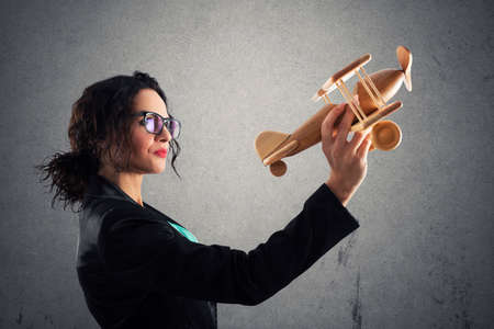 Businesswoman play with a toy aircraft. Concept of company startup and business success