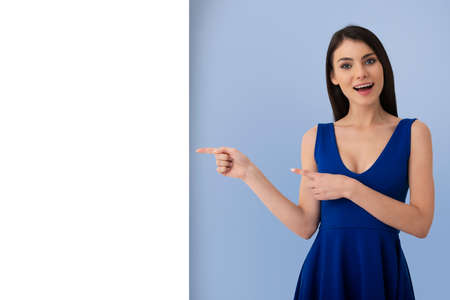 Surprised girl indicates a blank space for your textの写真素材