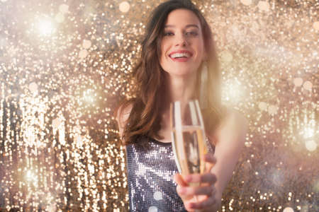 Girl drinks sparkling wine to celebrate the new yearの写真素材