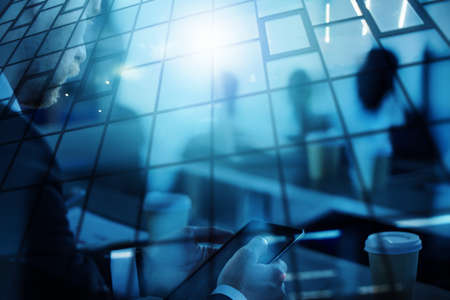 Business man works in office with tablet in the foreground.