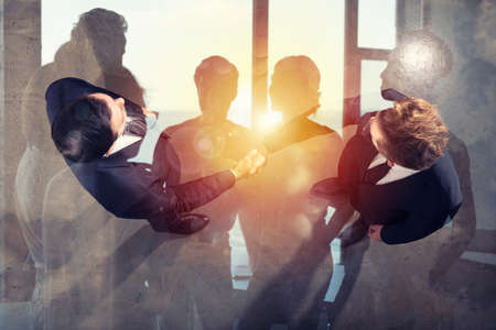 Handshaking business person in office. concept of teamwork and partnership. Double exposure