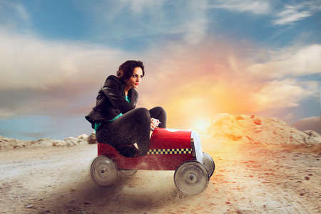 Businesswoman drives a toy car. Concept of competition and determination