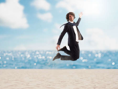 Businessman jumps on the sand. Concept of vacationの写真素材