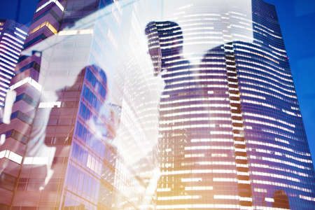 Businessmen that work together in office at night. Concept of teamwork and partnership. double exposureの写真素材