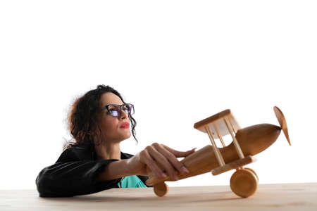 Businesswoman play with a toy aircraft. Concept of company startup and business success. Isolated on white background.の写真素材