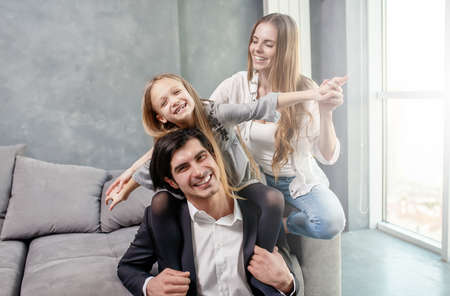 Happy little girl play with her mother and father