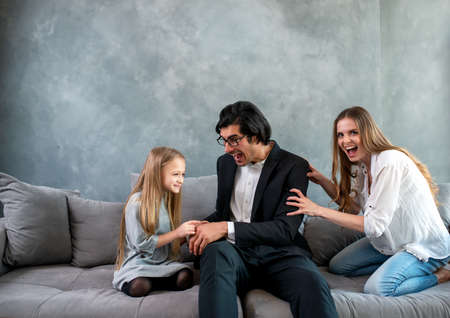 Happy little girl play with her mother and father