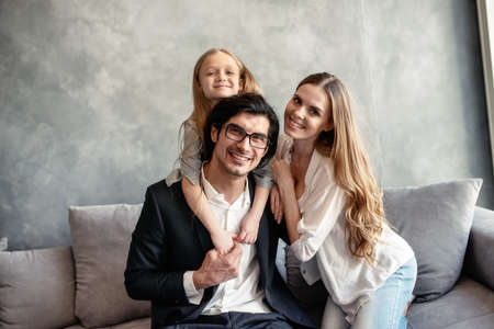 Happy little girl play with her mother and fatherの写真素材