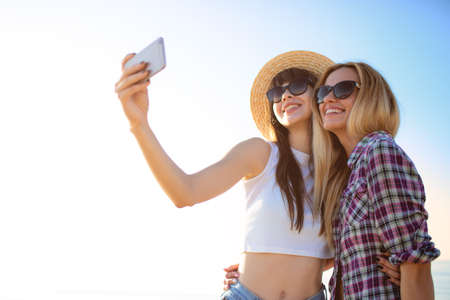 Happy group of friend makes a selfie with a mobile phone.の写真素材