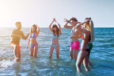 Group of friends having fun on the beach. Concept of summertimeの写真素材