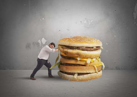 A man pushes a big sandwichの写真素材