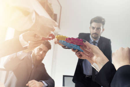 Business team connect pieces of gears. Teamwork, partnership and integration concept