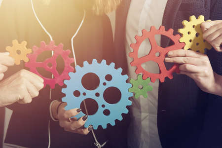 Business team connect pieces of gears. Teamwork, partnership and integration concept