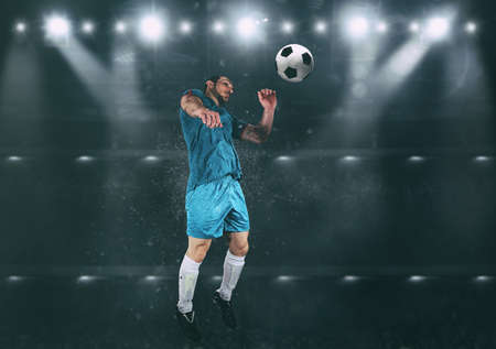 Football scene at night match with player jumping to hit the ball with headの写真素材