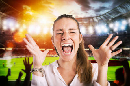 Football scene at night match with cheering fans at the stadiumの写真素材