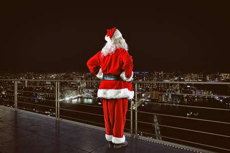 Christmas is coming. Santa Claus on a roof view cityの写真素材