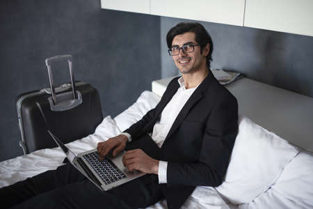 Businessman ready to travel works with his laptop