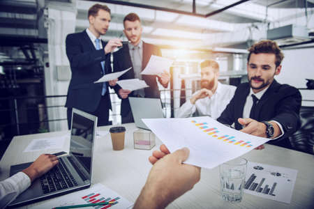 Team of people work together with statistics. concept of teamwork and partnership.の写真素材