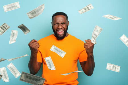 Boy wins money. Amazed and surprised expression face. Light blue backgroundの写真素材