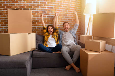 Happy couple have to move and arrange all the packages. Concept of success, change, positivity and futureの写真素材