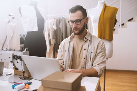 Seamstress works to new clothes ordered by internet clientの写真素材