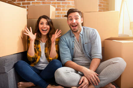 Happy couple have found a new home and they need to arrange all the packages. Concept of success,...