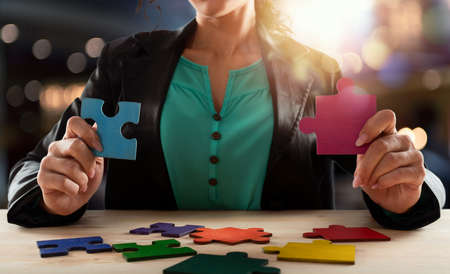 Businesswoman join two puzzle pieces.