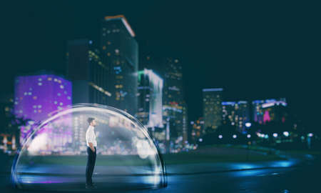 Businessman safely inside a shield dome in the city at night.の写真素材