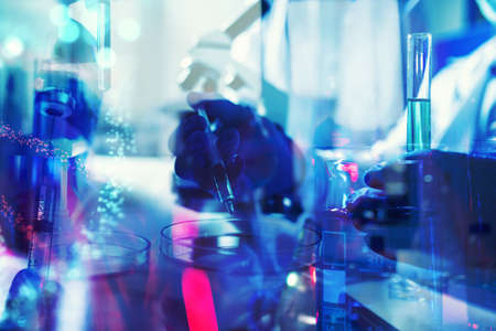 Doctor in the laboratory analyzes samples under a microscope.の写真素材